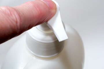 Squeezing a pump bottle for easy dispensing of liquid soap © aviavlad