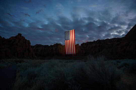 Giant American Flag Hanging Between Red Rock Desert Cliffs at Sunset in Utah to Celebrate the Patriotic America 250 Celebration for 4th of July 04