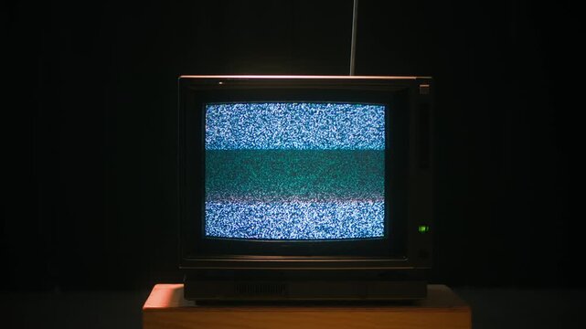 Retro TV, vintage television In a nostalgic setup, a retro TV displays grain on screen, scary halloween night device good for chroma key and green screen