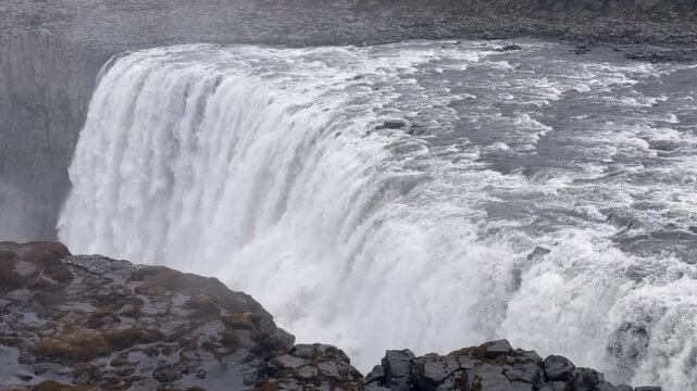 Mighty Dettifoss waterfall in northeastern Iceland. Immense volumes of water from the Jokulsa a Fjollum river cascade over the cliff