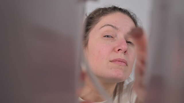 A Caucasian woman looks into a bag and is pleasantly surprised. Inside view.