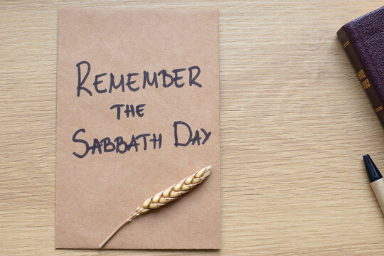 Remember the Sabbath Day, handwritten text on rustic note with holy bible. Christian biblical concept.