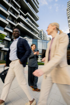 People walking in a modern city area with buildings in the background during daytime