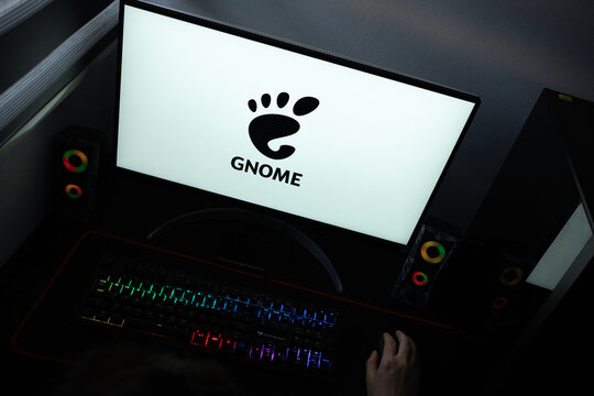Punta Arenas, Chile &ndash; June 12, 2026: A desktop PC monitor showing the GNOME open-source graphical user interface branding on a white background, surrounded by an illuminated gaming keyboard and periph