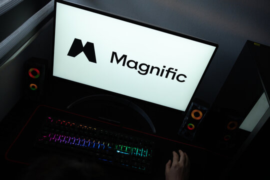 Punta Arenas, Chile &ndash; June 12, 2026: A desktop PC monitor showing the Magnific artificial intelligence branding on a white background, surrounded by an illuminated gaming keyboard and peripherals