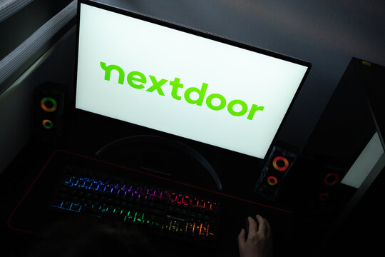 Punta Arenas, Chile &ndash; June 17, 2026: The official green typographic logo of the Nextdoor social network displayed on a computer screen in a dark room workspace setup