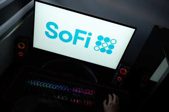Punta Arenas, Chile &ndash; June 17, 2026: The official light blue typographic logo and dot grid icon of SoFi financial services company displayed on a computer screen in a dark room workspace setup