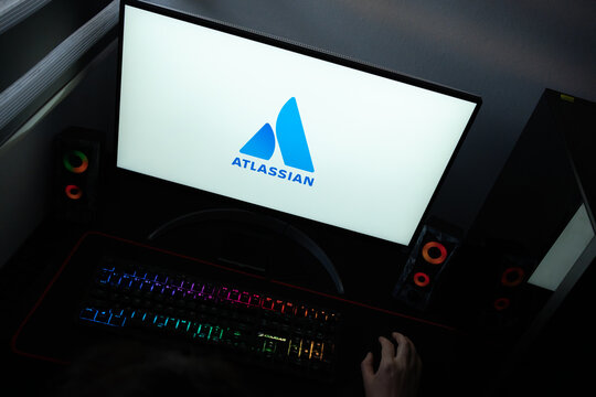 Punta Arenas, Chile &ndash; June 12, 2026: The official blue Atlassian software company logo displayed on a computer screen in a dark workspace setup with an RGB backlit keyboard