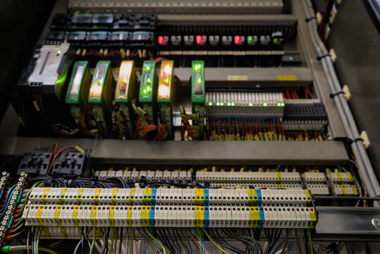 Multi tier terminal blocks with color coded wiring against blurred background of industrial control automation rack