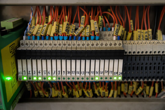 Row of industrial interface relays with active green LED indicators on control panel terminal board