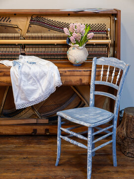 Rustic Interior with Vintage Upright Piano, Blue Chair and Pink Hyacinths