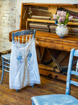 Rustic Interior with Vintage Upright Piano, Blue Chair and Pink Hyacinths