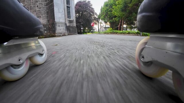 Powerful closeup action of man skating fast on inline skates showing dynamic motion, speed, technique, outdoor fitness and urban energy