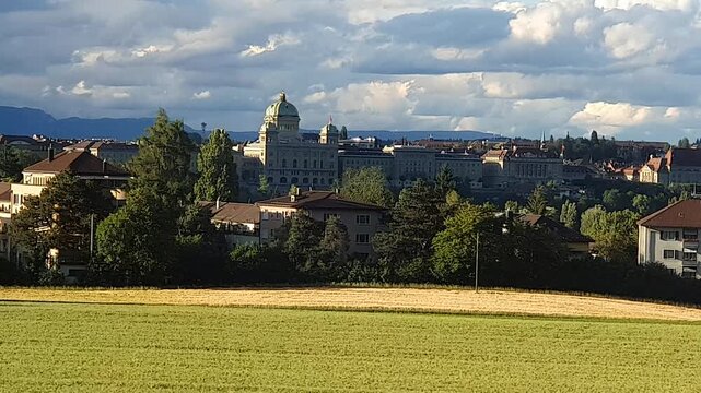 Switzerland parliament building seen fron a train across the countryside.