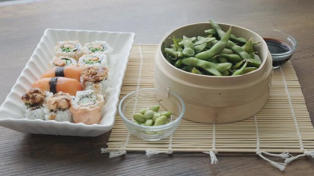sushi nigiri platter served withsteamed edamame in a traditional bamboo steamer