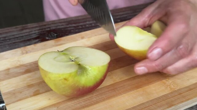 Juicy apple cut into pieces on wooden board during fresh fruit preparation with detailed texture and healthy natural food concept close up.