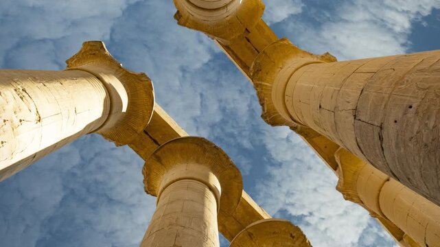 Timelapse of white clouds on blue sky over Ancient Egypt Papyrus columns of the Great Hypostyle Hall in Karnak temple Luxor, Egypt