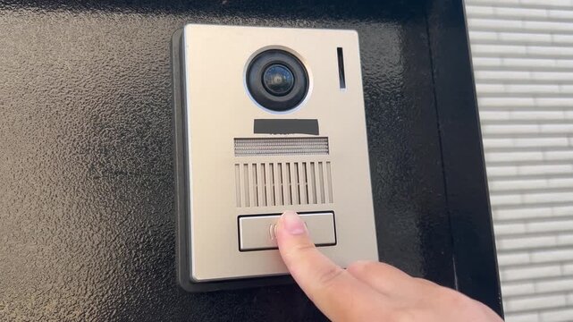 インターホンを押す指