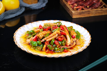 Fototapeta premium Chinese Stir-Fried Squid with Peppers - Traditional Spicy Seafood Dish on Decorative Plate