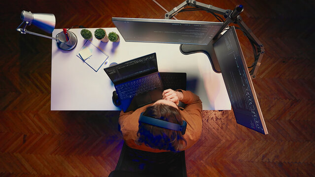 Top-down view of developer typing complex code in home office, listening music and developing software application.