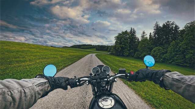 Riding classic retro motorcycle  naked bike on land road curves on sunny summer day - POV handlebar forward view in motion