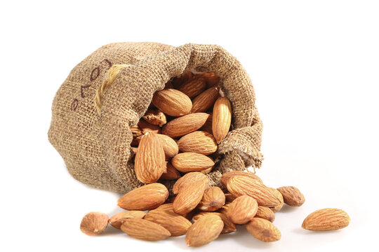 Raw Almonds in Burlap Sack - Healthy Natural Nuts Spilling Out on White Background