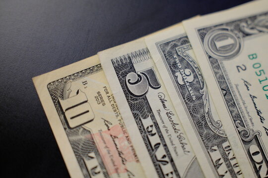 Dollar banknotes from 1 to 10 dollars, close-up top view. US dollar banknotes in 1, 2, 5 and 10 dollar denominations, top view