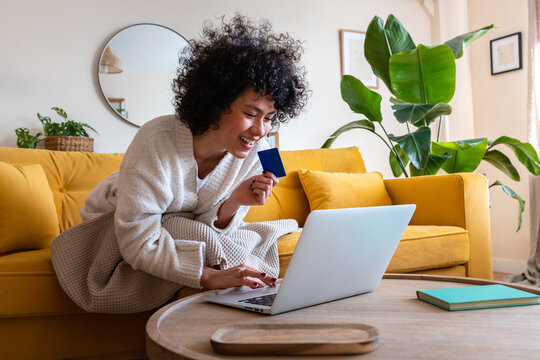 Woman shopping online with credit card at home