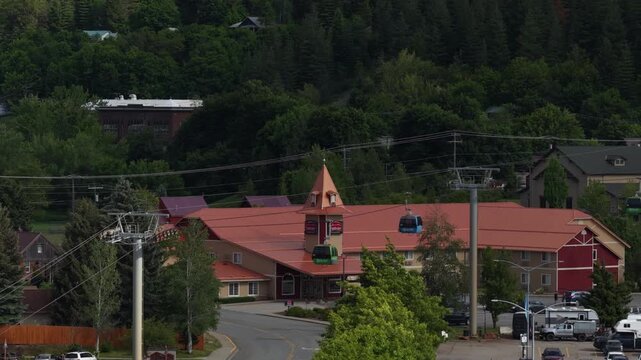 Aerial of ski resort village and gondola in Kellogg Idaho in spring with dense forest backdrop