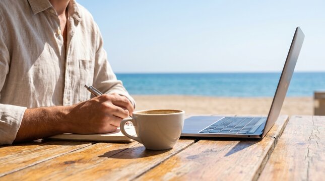 Digital nomad man working on laptop at beach cafe table with coffee, remote work lifestyle concept, freelance professional writing in notebook outdoors