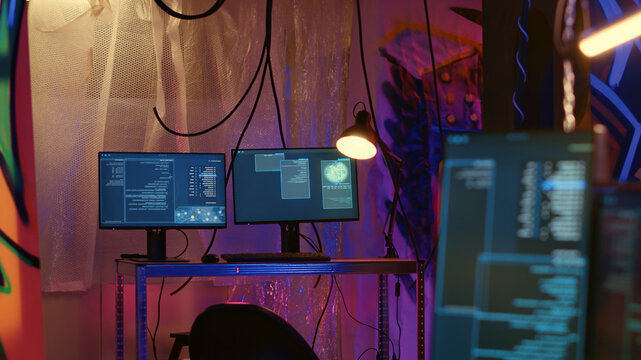 Software interface on computer screen showing programming code used for making malware in empty warehouse with graffiti sprayed on walls, Hacking script running on PC monitors in underground base.