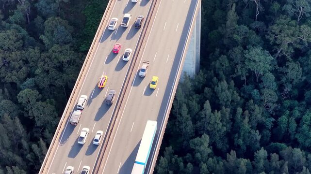 Fast aerial vertical view of highway bridge M1 Australia heavy holiday traffic driving slow.