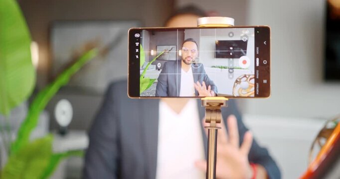 Zooming in on a man recording video indoors