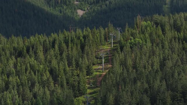 Aerial of dense forest and chair lift at ski resort in Kellogg Idaho in spring in daylight
