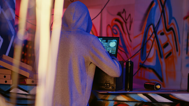 Close-up shot of hacker in underground bunker using network vulnerabilities to exploit servers, trying to break computer systems at night, African American cybercriminal breaching networks.