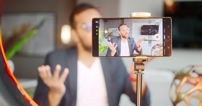 Businessman recording video with smartphone and ring light setup