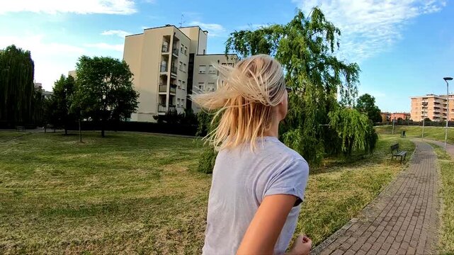 SLOW MOTION of running woman on training outdoor in the park for healthy cardio jogging at sunset. Leggings and colorful gym shoes dress. back side view.