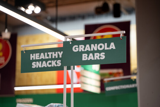 Close up of healthy snacks and granola bars section sign in grocery store.
