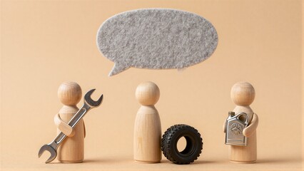 Three wooden figures with tools and a tire under an empty speech