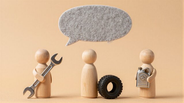 Three wooden figures with tools and a tire under an empty speech