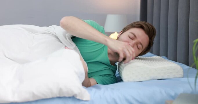Man lying on bed with orthopedic pillow at home