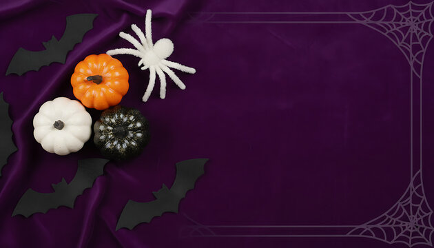 Creative Halloween flatlay arrangement with petite pumpkin spectral black spider and bat on vibrant violet backdrop with vertical copy space for festive holiday greeting or ad layout