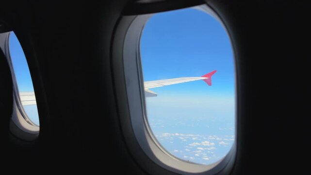 Airplane Windows View Aircraft Wing with Red Winglet and Blue Sky