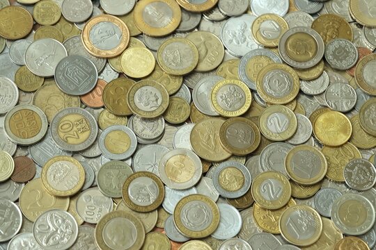 Big pile of coins from different money currencies. Treasure and numismatics concept
