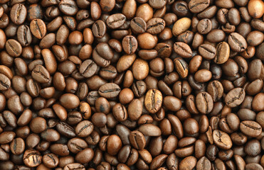 Fototapeta premium Detailed view on brown roasted coffee beans in big pile on table close up