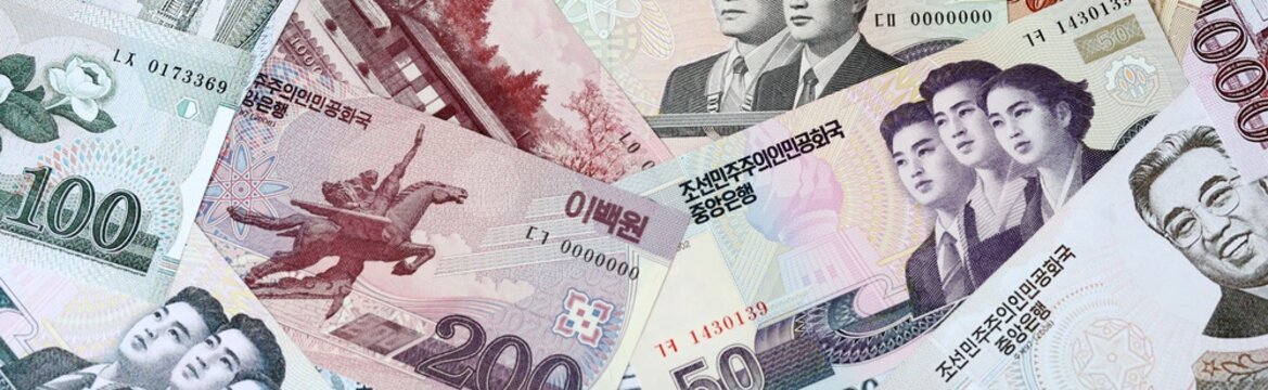 North Korean won money bills in pile on table. North Korea KPW currency cash close up