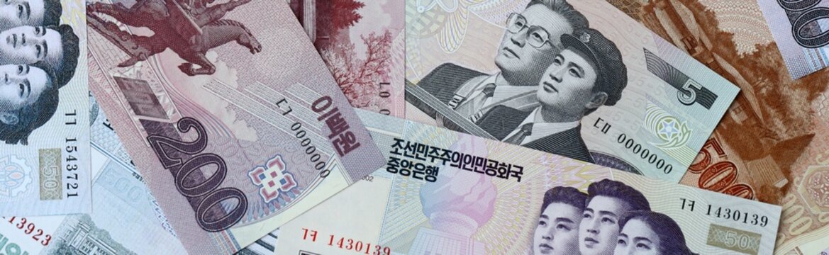 North Korean won money bills in pile on table. North Korea KPW currency cash close up