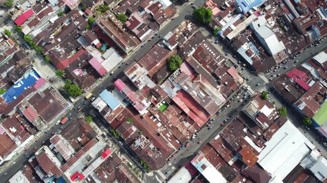 A high-angle view of a densely populated urban area in Iquitos, Peru with a focus on rooftops, buildings, and diagonal streets.