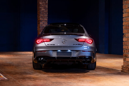Grey Mercedes CLA 45 S centered rear view indoors, Luxury sports sedan in studio showroom