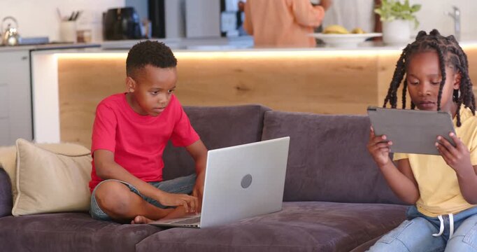 African American family at home sitting kids using laptop tablet camera panning parents making meal